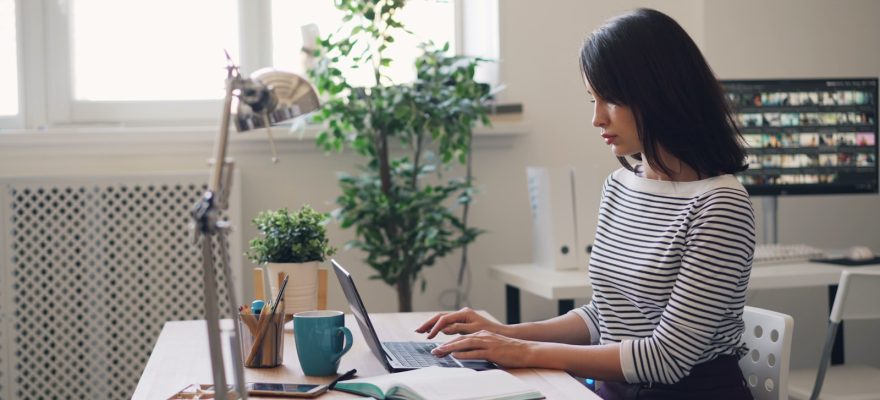 a woman sitting at a desk using a laptop computer
