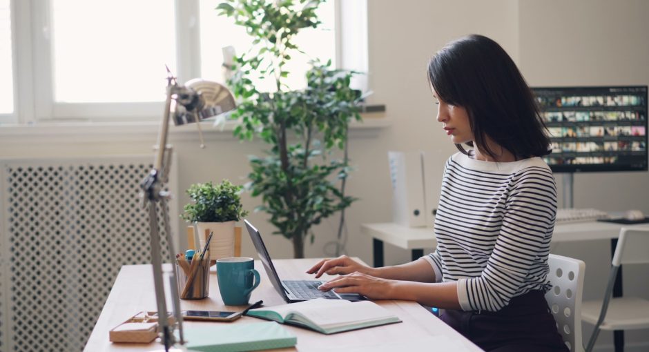 a woman sitting at a desk using a laptop computer