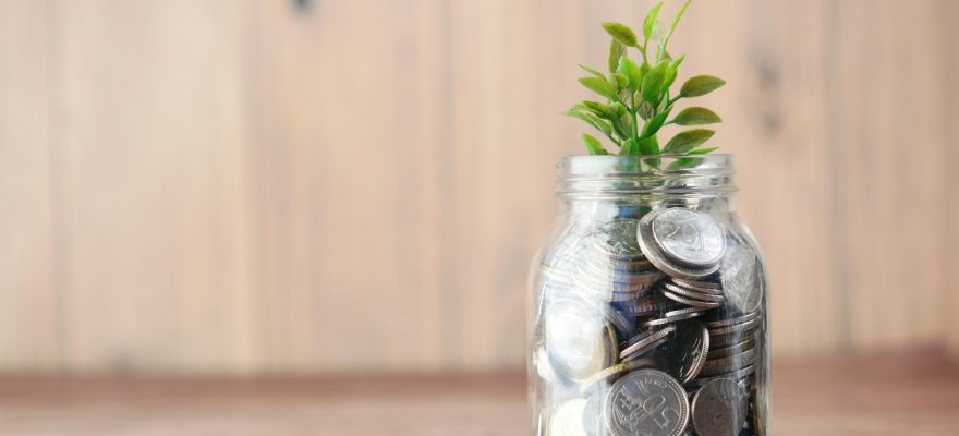 a glass jar filled with coins and a plant