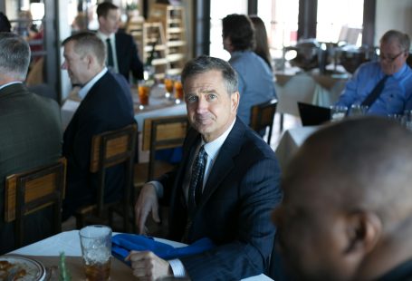 man in black suit jacket sitting on chair
