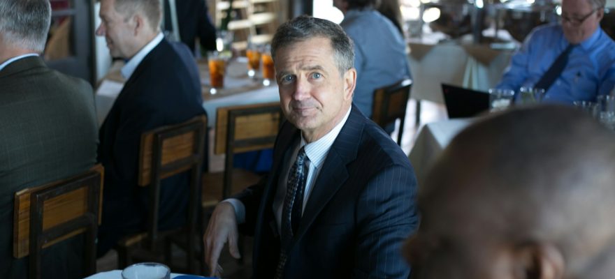 man in black suit jacket sitting on chair