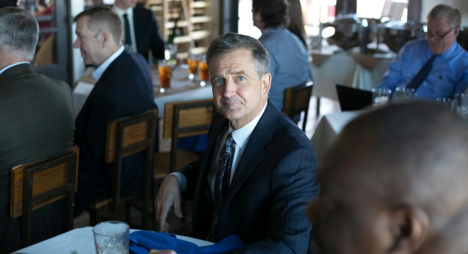 man in black suit jacket sitting on chair