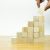 A person placing a piece of wood into a pyramid